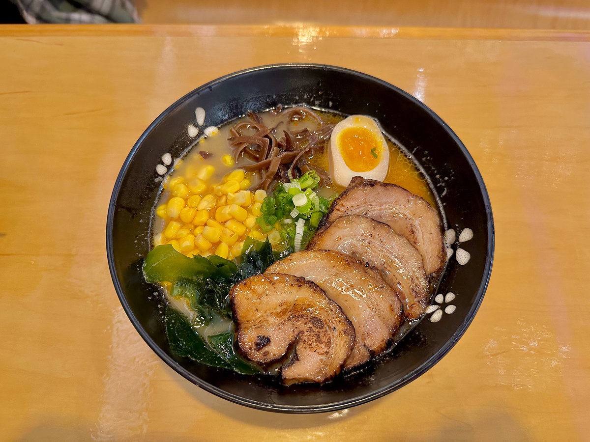 miso ramen in a black bowl on a table
